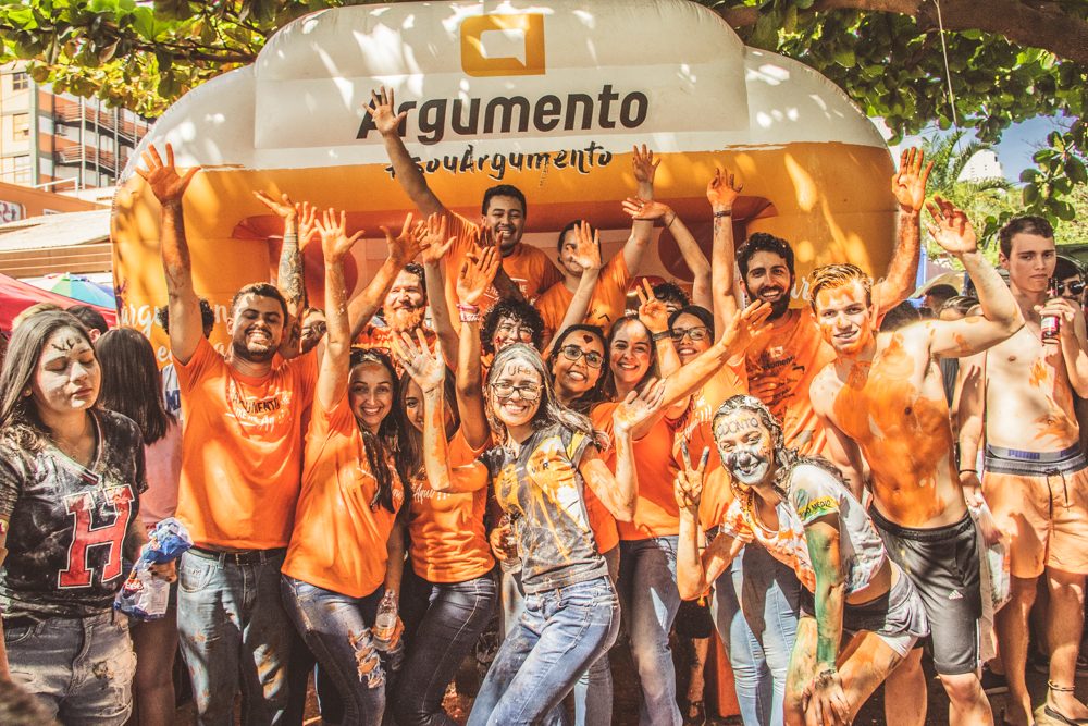 Grupo de alunos comemorando em frente ao inflável da Argumento