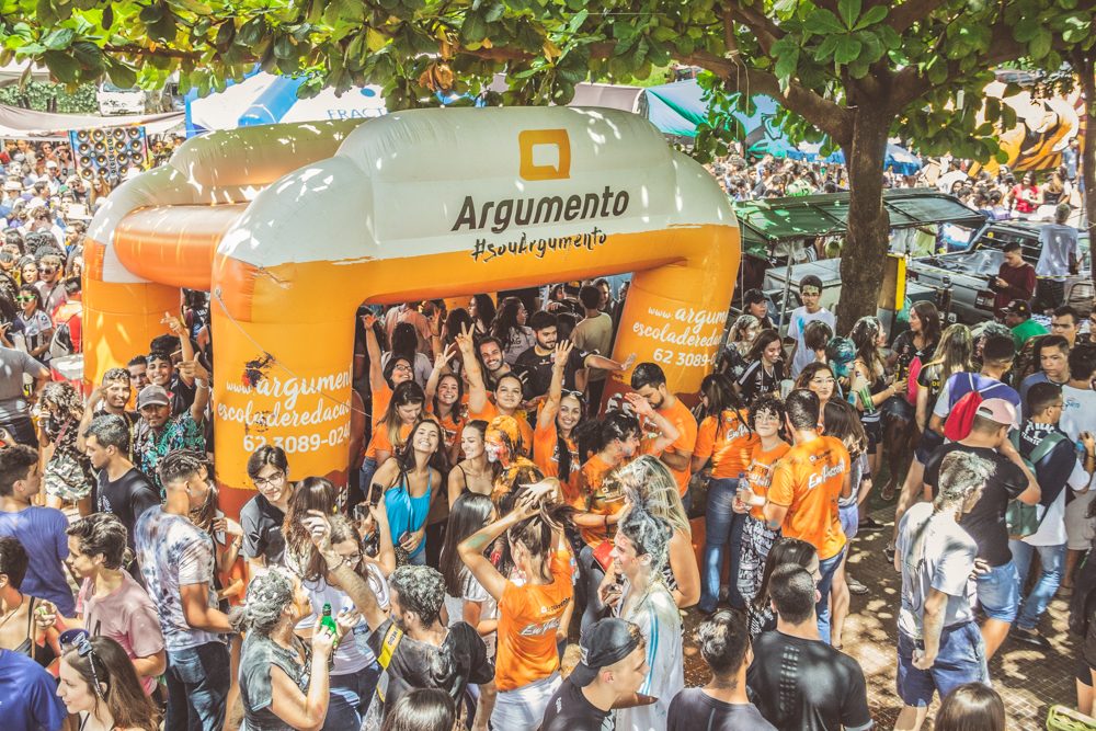 Multidão de alunos aprovados comemorando na festa da Argumento